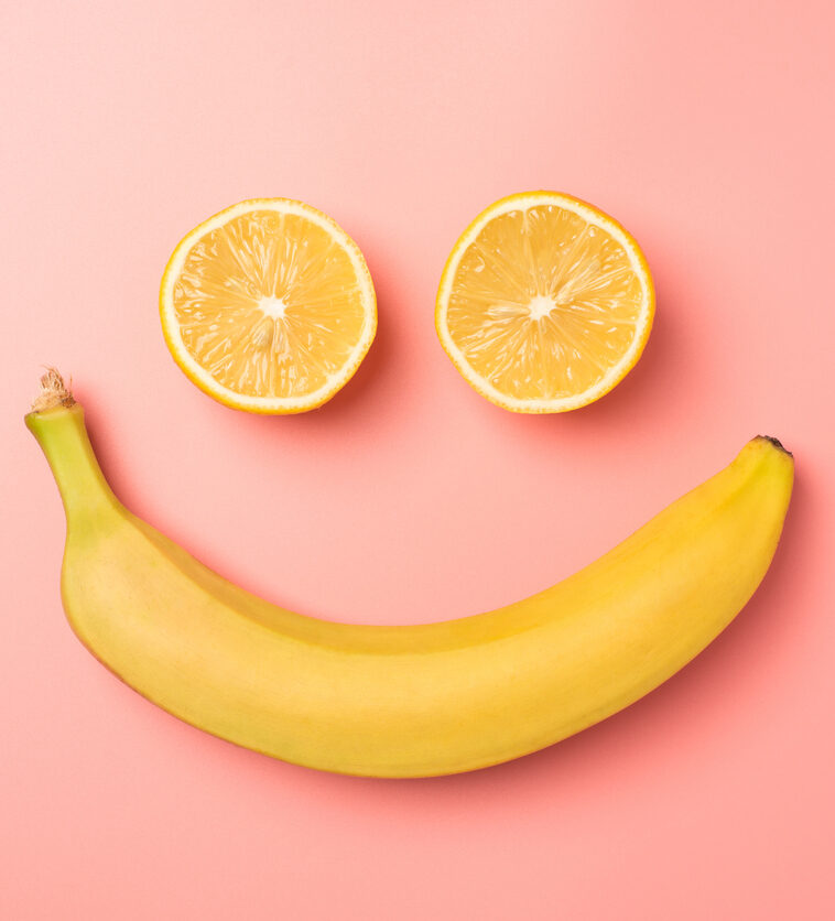Sourire avec une orange et une banane.